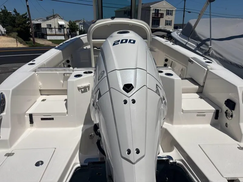 Slide: The Image of 2026 Sailfish 232 CC boat interior with powerful 200 HP engine, docked in a residential area. - 17