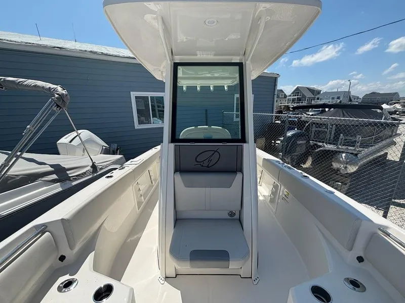 Slide: The Image of 2026 Sailfish 232 CC boat interior with seating and console, docked under clear skies. - 7