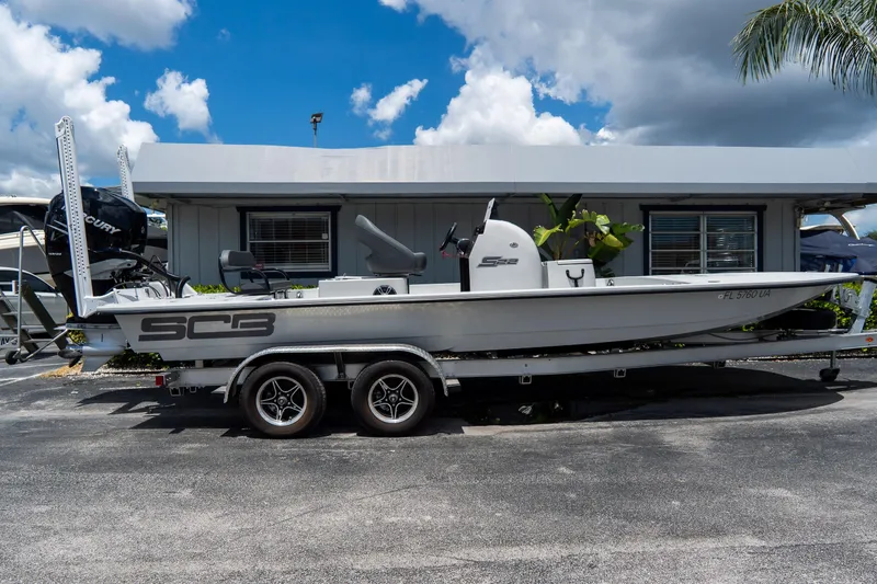 The Image of 2021 SCB S22 boat on trailer, parked outdoors under a cloudy sky. - 0