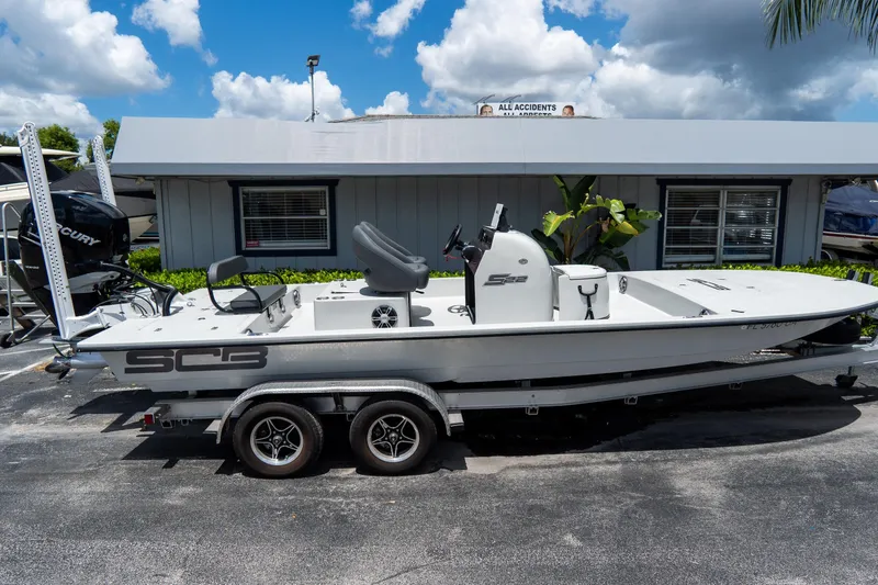 Slide: The Image of 2021 SCB S22 boat on trailer, parked outdoors under a cloudy sky. - 1