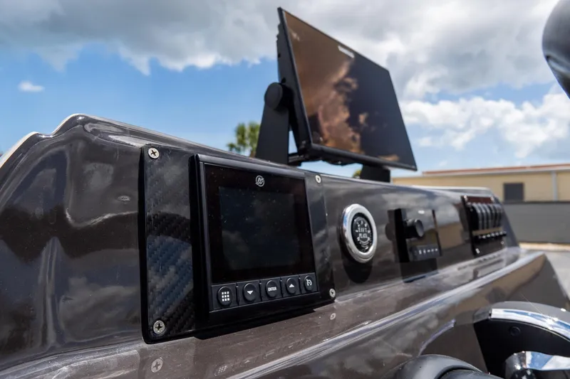 Slide: The Image of 2021 SCB S22 boat dashboard with modern controls and navigation screen under a cloudy sky. - 14