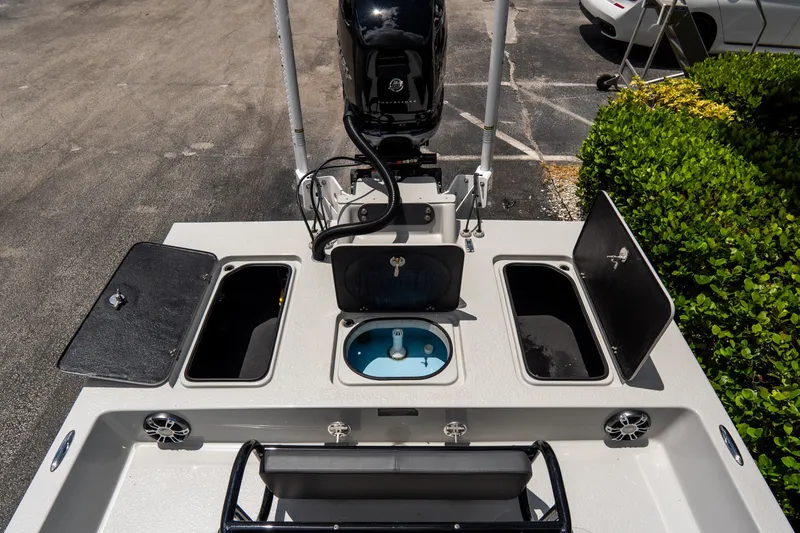 Slide: The Image of 2021 SCB S22 boat deck with storage compartments and motor, parked outdoors. - 21