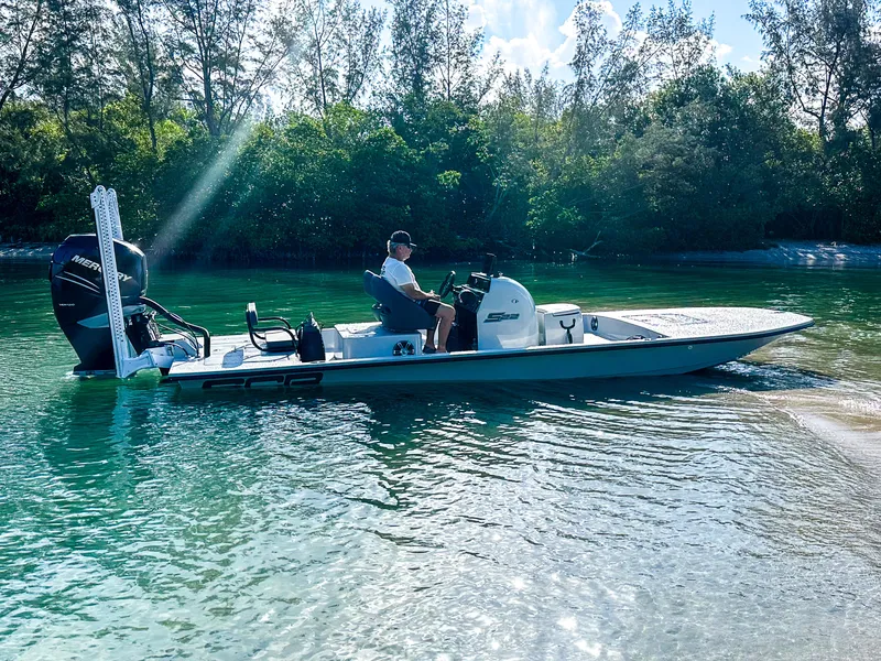 Slide: The Image of 2021 SCB S22 boat cruising on clear water near a forested shoreline. - 25