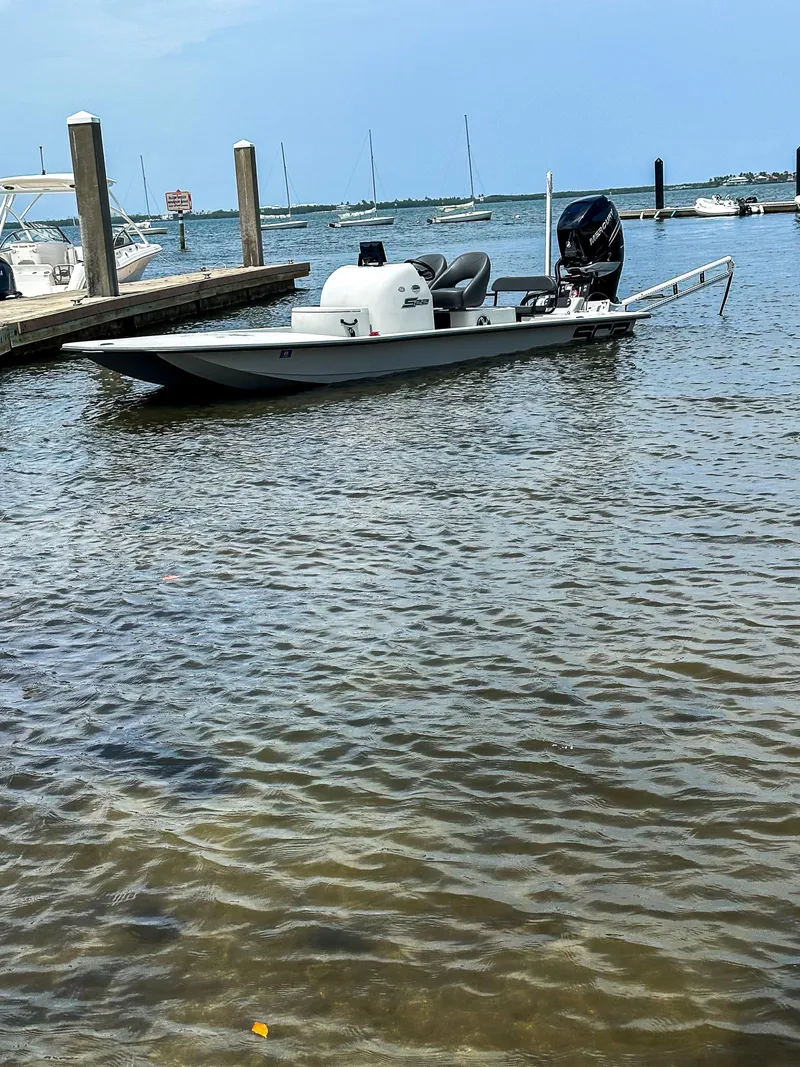 Slide: The Image of 2021 SCB S22 boat docked in a marina with calm waters. - 26