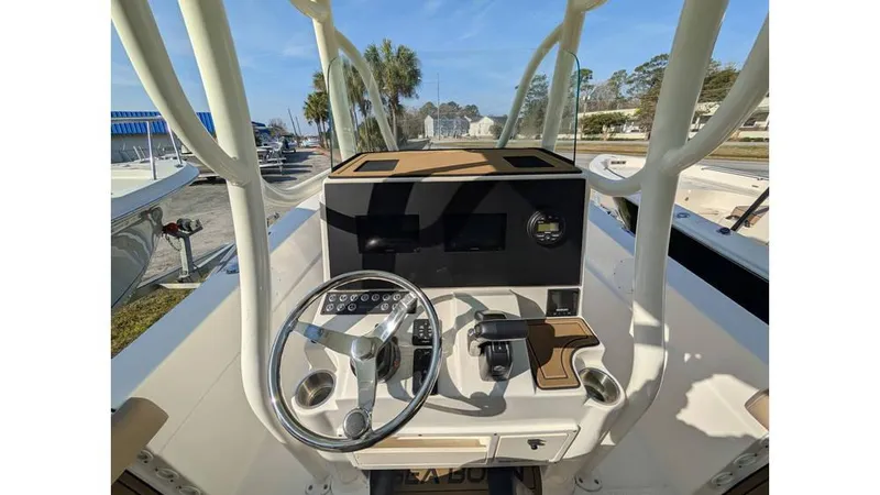 Slide: The Image of 2024 Sea Born LX22 Center Console boat dashboard with steering wheel and controls. - 7