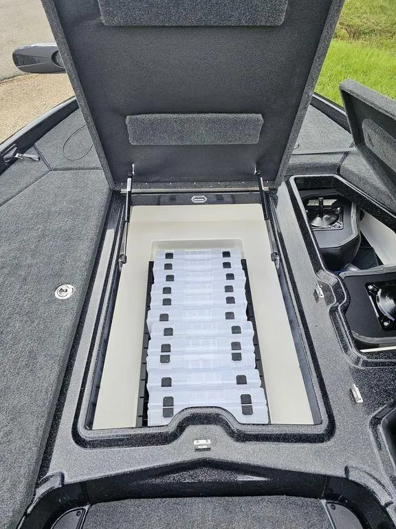 Slide: The Image of Open storage compartment in 2026 Skeeter ZXE20 boat, showcasing organized tackle boxes. - 11