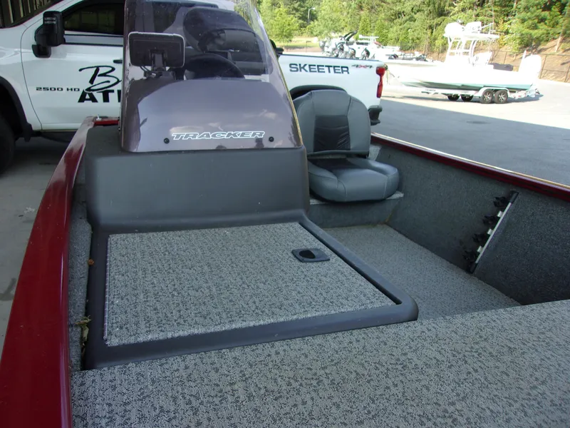 Slide: The Image of 2020 Bass Tracker 160 PRO boat interior with seating and console, parked outdoors. - 9