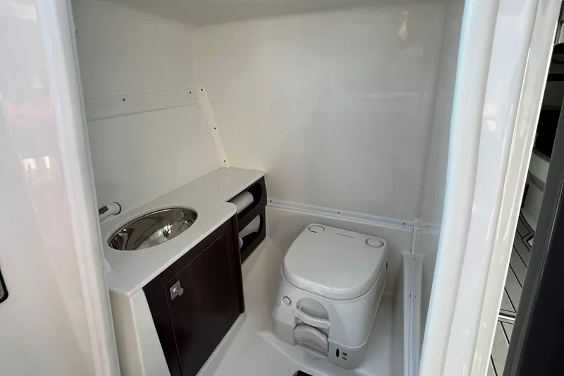 Slide: The Image of 2019 Monterey M6 boat bathroom with sink, cabinet, and portable toilet. - 10
