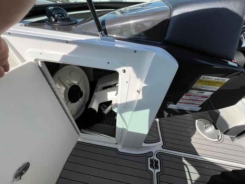 Slide: The Image of 2019 Monterey M6 boat storage compartment with open door, revealing interior equipment. - 13