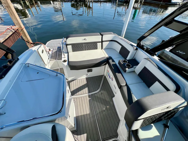 Slide: The Image of 2019 Monterey M6 boat interior with sleek seating and modern design at a marina. - 14