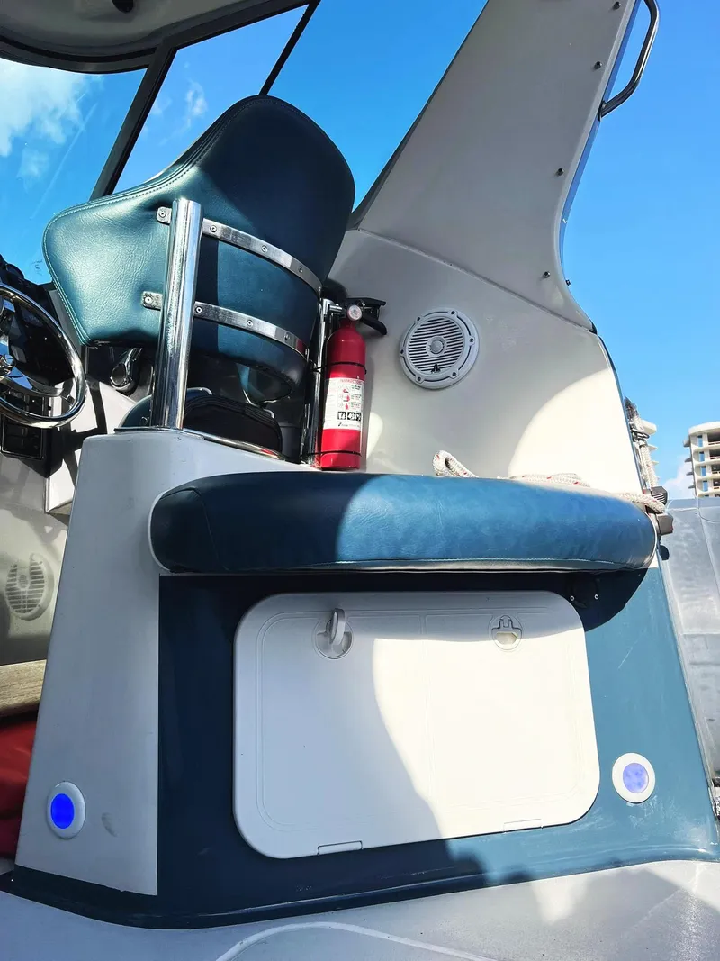Slide: The Image of Interior of a 2000 Protector Targa 28 boat with blue seating and fire extinguisher. - 12