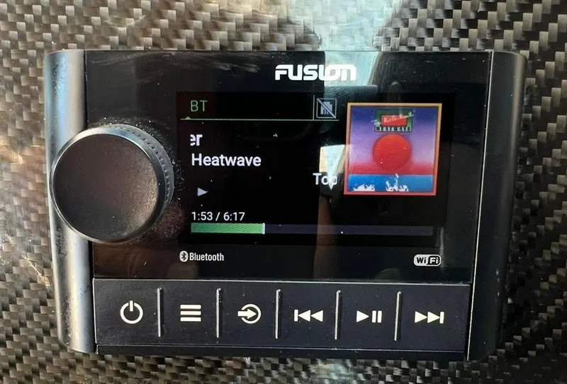 Slide: The Image of Fusion marine stereo displaying music track on a carbon fiber background. - 17
