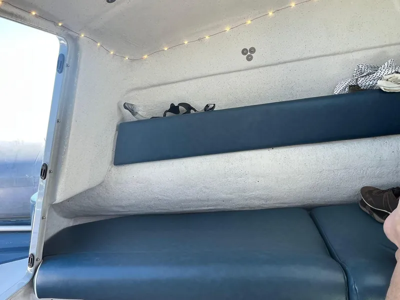 Slide: The Image of Interior of a 2000 Protector Targa 28 boat with blue seating and string lights. - 29