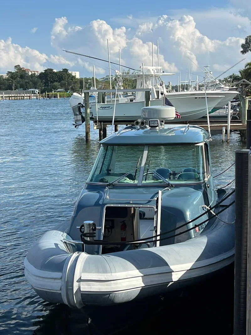 Slide: The Image of 2000 Protector Targa 28 boat docked on a sunny day with fluffy clouds. - 4