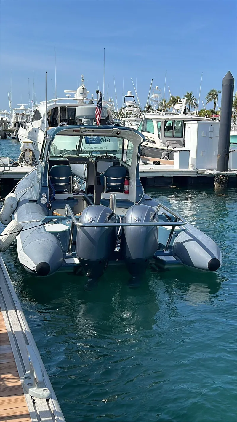 Slide: The Image of 2000 Protector Targa 28 boat docked with dual outboard motors in a marina. - 6