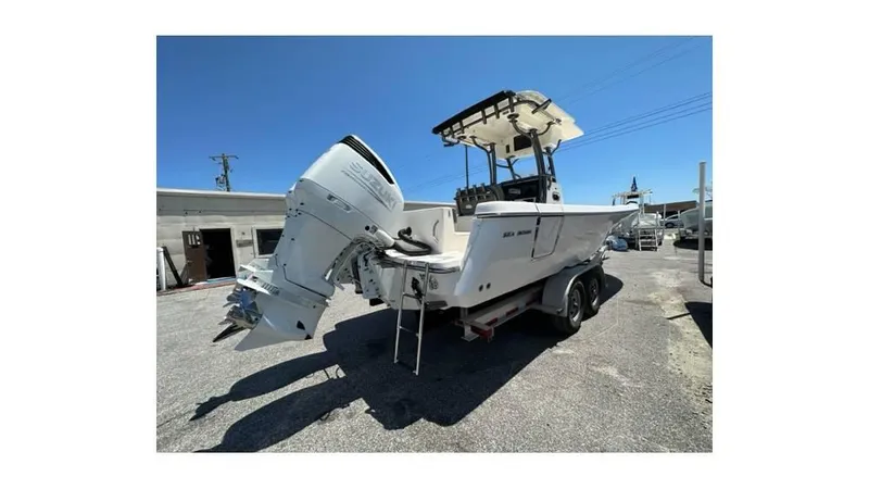 Slide: The Image of 2024 Sea Born FX25 Bay boat on trailer, rear view, sunny day. - 2