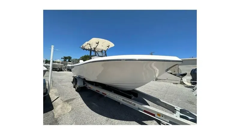 Slide: The Image of 2024 Sea Born FX25 Bay boat on trailer under clear blue sky. - 3