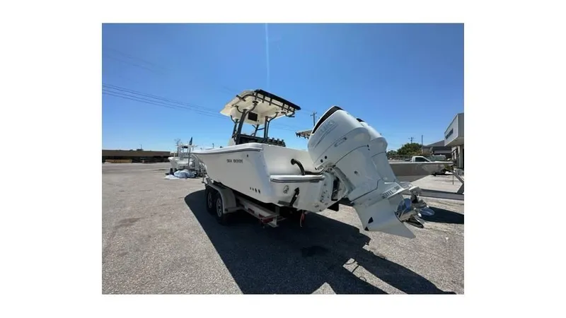 Slide: The Image of 2024 Sea Born FX25 Bay boat with dual outboard motors on a trailer. - 34