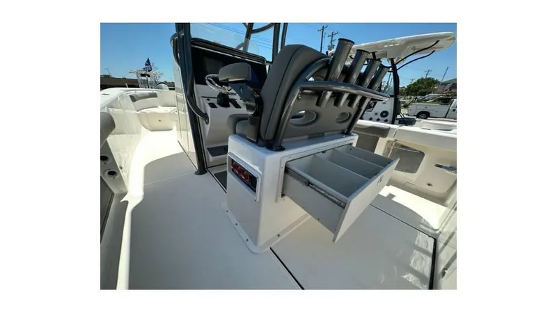 Slide: The Image of 2024 Sea Born FX25 Bay boat interior with open storage compartment and rod holders. - 6