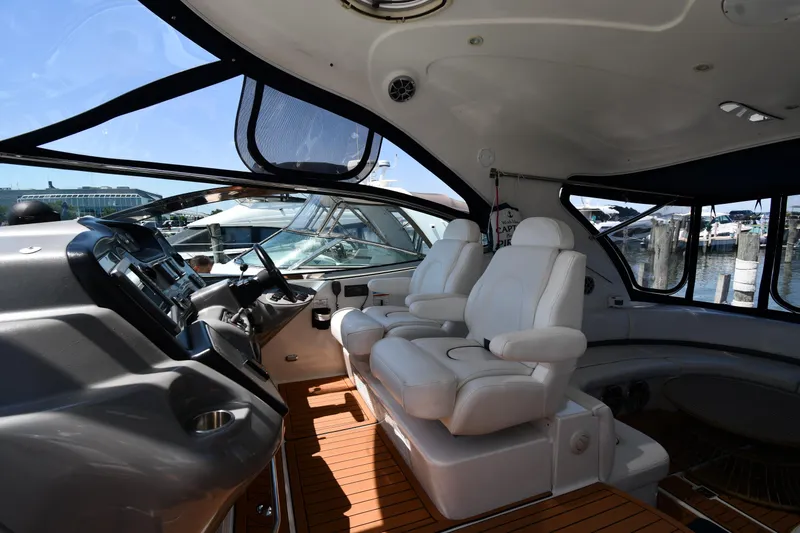 Slide: The Image of Interior of 2005 Cruisers Yachts 520 Express with white leather seats and wooden flooring. - 13