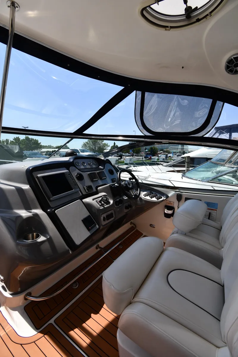 Slide: The Image of 2005 Cruisers Yachts 520 Express cockpit with modern controls and white seating. - 16