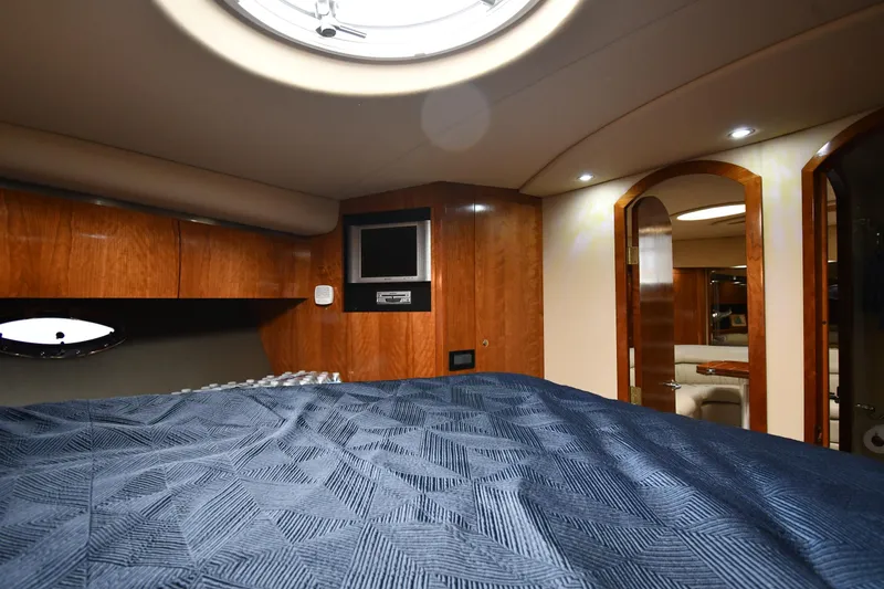 Slide: The Image of Luxurious cabin interior of 2005 Cruisers Yachts 520 Express with wood paneling and blue bedding. - 37