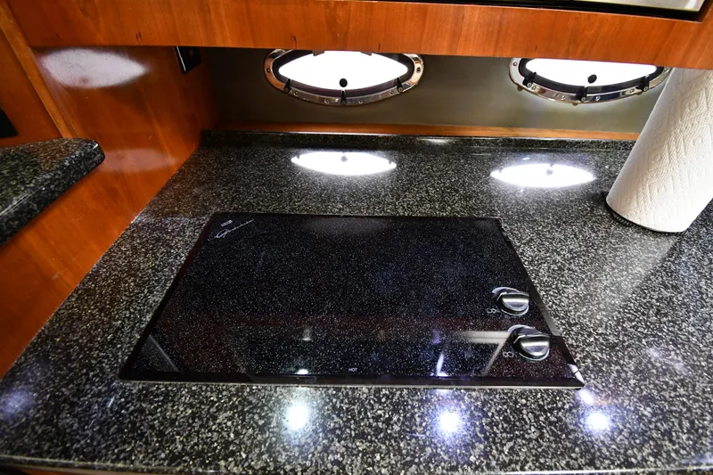 Slide: The Image of 2005 Cruisers Yachts 520 Express kitchen with granite countertop and electric stove. - 48