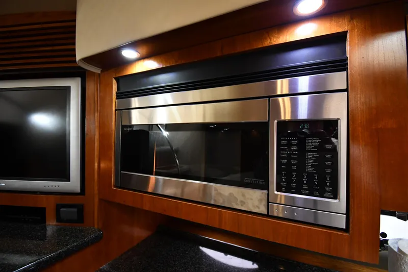 Slide: The Image of Modern kitchen area in 2005 Cruisers Yachts 520 Express with stainless steel microwave. - 49