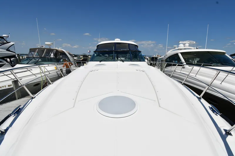 Slide: The Image of 2005 Cruisers Yachts 520 Express docked among other boats under a clear blue sky. - 6