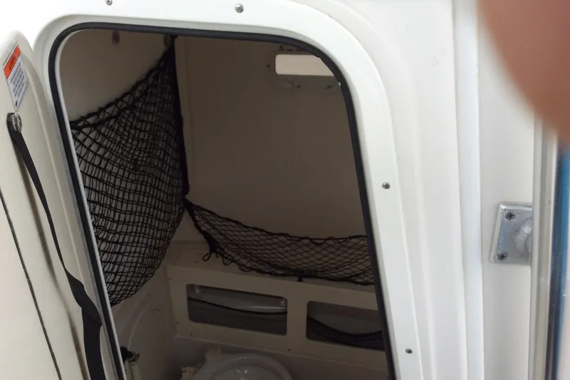 Slide: The Image of Interior of 2011 Sailfish Center Console boat with storage nets and compact toilet. - 10