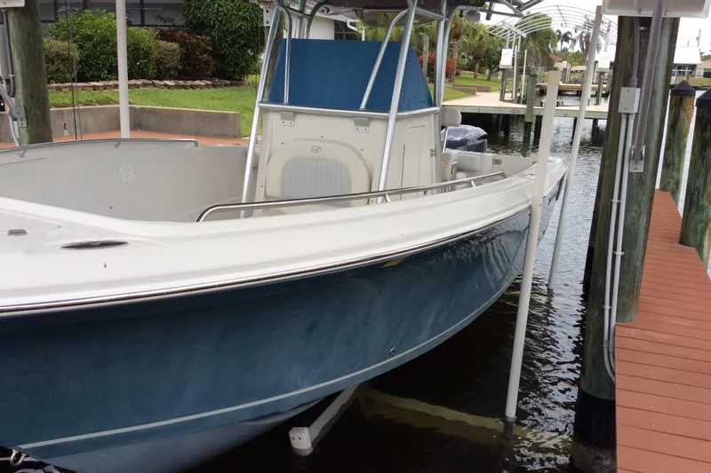 Slide: The Image of 2011 Sailfish Center Console boat docked in a marina, featuring a sleek blue hull. - 2