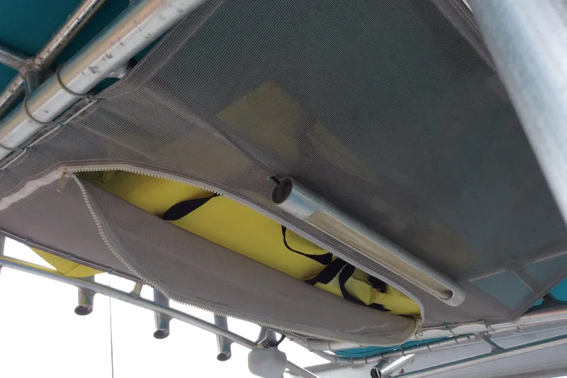 Slide: The Image of Storage compartment on a 2011 Sailfish Center Console boat, featuring a mesh zippered cover. - 6