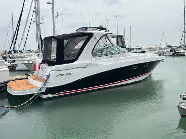 The Image of 2007 Four Winns 378 Vista yacht docked in marina, featuring sleek design and black canvas cover. - 0