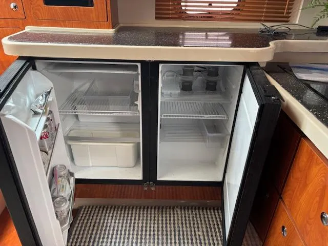 Slide: The Image of 2007 Four Winns 378 Vista yacht kitchen with open fridge, wooden cabinets, and countertop. - 19