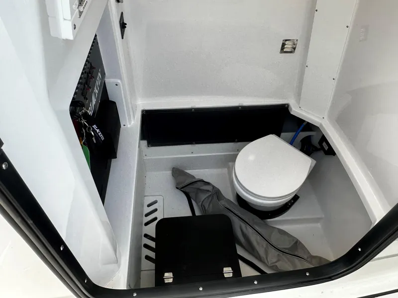 Slide: The Image of 2025 Blackfin 272CC boat interior with compact marine toilet and storage area. - 11