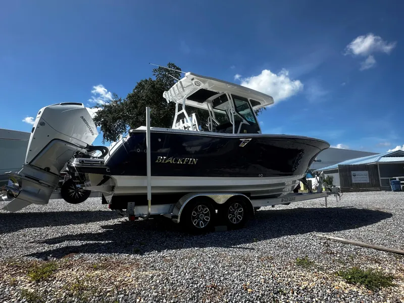 Slide: The Image of 2025 Blackfin 272CC boat on trailer under clear blue sky. - 2