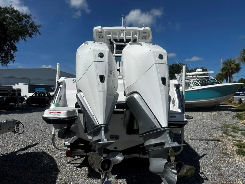 Slide: The Image of 2025 Blackfin 272CC boat with dual outboard engines, parked outdoors under a clear sky. - 3