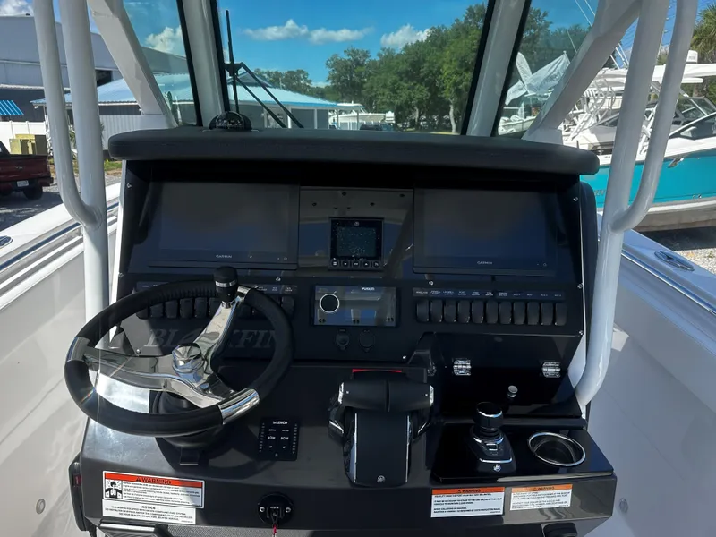 Slide: The Image of 2025 Blackfin 272CC boat dashboard with steering wheel and navigation controls. - 6