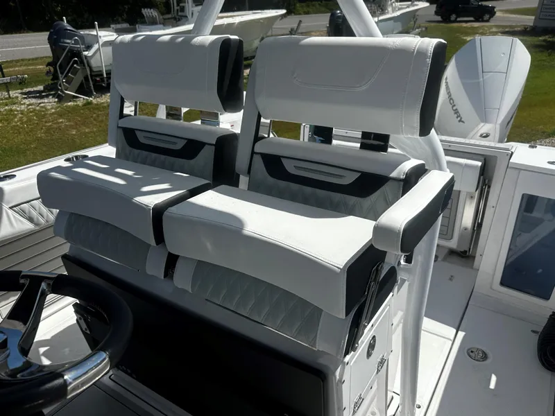 Slide: The Image of 2025 Blackfin 272CC boat interior with white cushioned seats and steering wheel. - 7