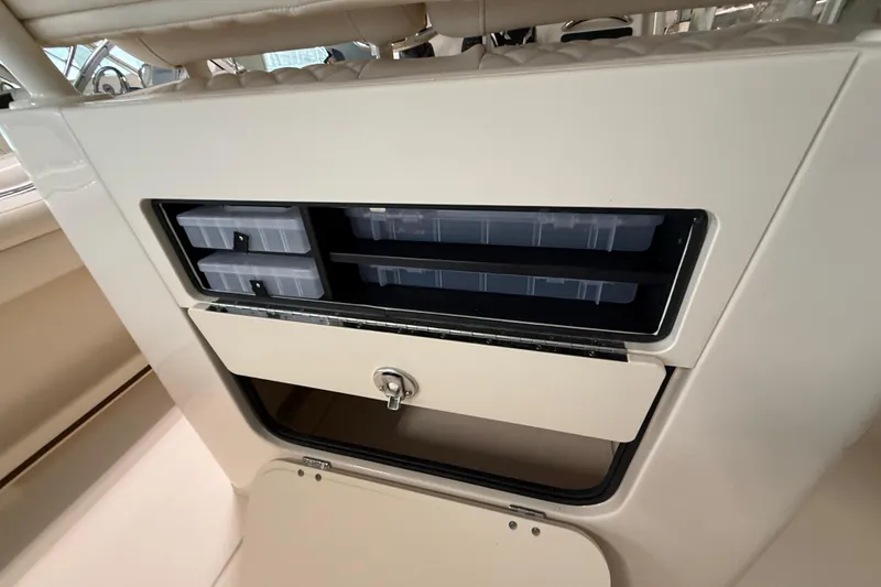 Slide: The Image of 2026 Grady-White Fisherman 216 boat storage compartment with organized tackle boxes. - 12
