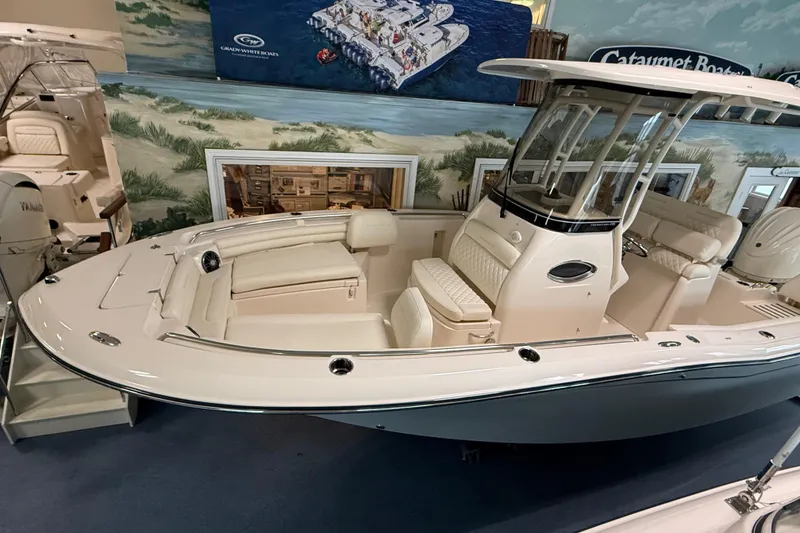 Slide: The Image of 2026 Grady-White Fisherman 216 boat displayed in showroom with seating and console. - 6