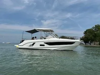 Slide: The Image of 2023 Beneteau Flyer 9 SUNdeck boat on calm water under a blue sky. - 4