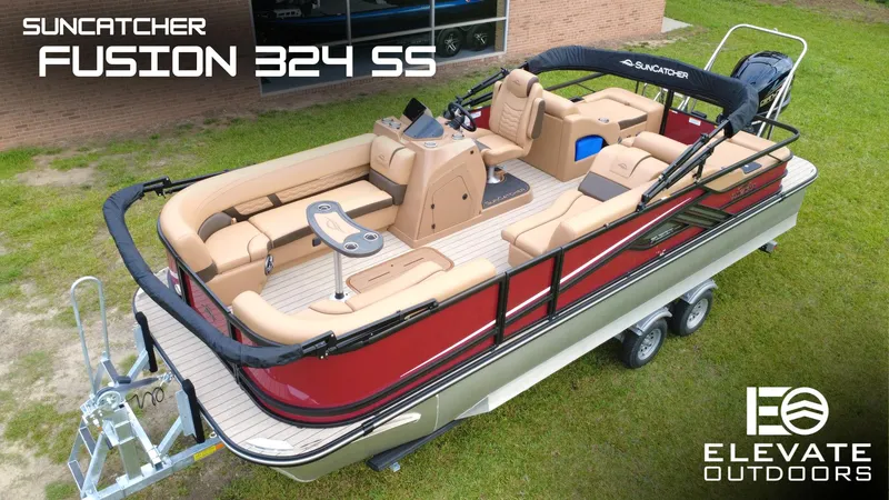 The Image of 2025 SunCatcher Fusion 324SS pontoon boat, red and beige interior, on trailer, outdoor setting. - 1