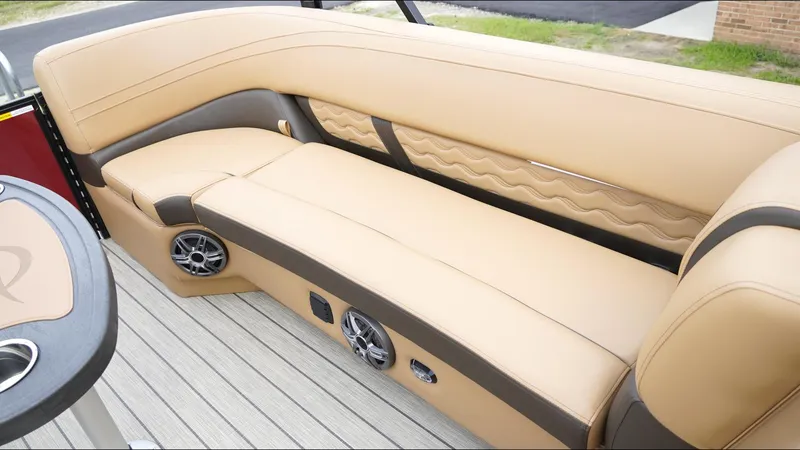 Slide: The Image of 2025 SunCatcher Fusion 324SS boat interior with beige seating and built-in speakers. - 18