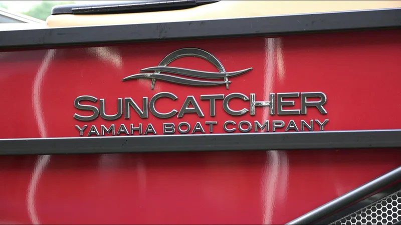 Slide: The Image of 2025 SunCatcher Fusion 324SS boat logo on red surface, Yamaha Boat Company branding. - 25