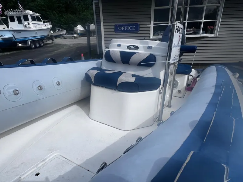 Slide: The Image of 2015 Smuggler Strata 520 boat for sale, featuring blue and white seating, docked near office. - 3