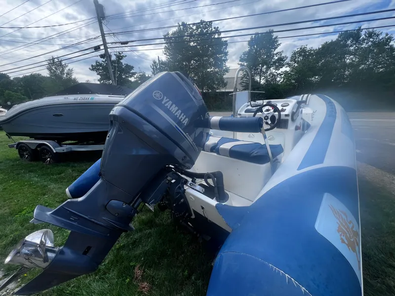 Slide: The Image of 2015 Smuggler Strata 520 boat with Yamaha outboard motor, parked on grass. - 6
