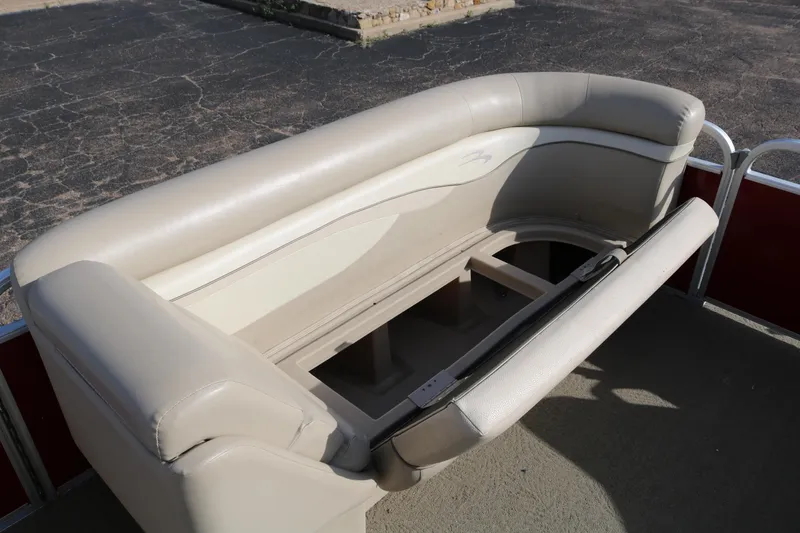 Slide: The Image of 2013 Bennington 22 SLX boat with open storage compartment and beige seating. - 12