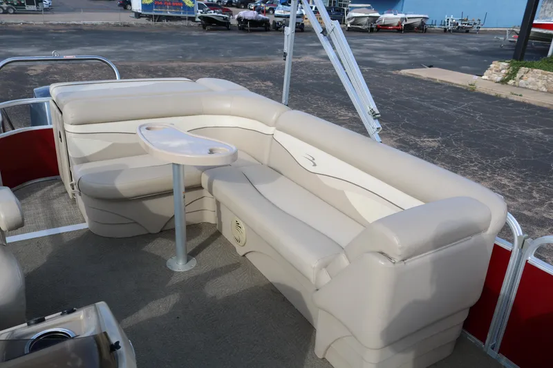 Slide: The Image of 2013 Bennington 22 SLX pontoon boat interior with beige seating and table. - 15