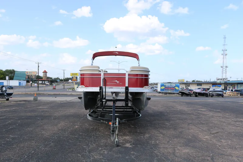 Slide: The Image of 2013 Bennington 22 SLX pontoon boat on trailer in parking lot, clear sky background. - 2